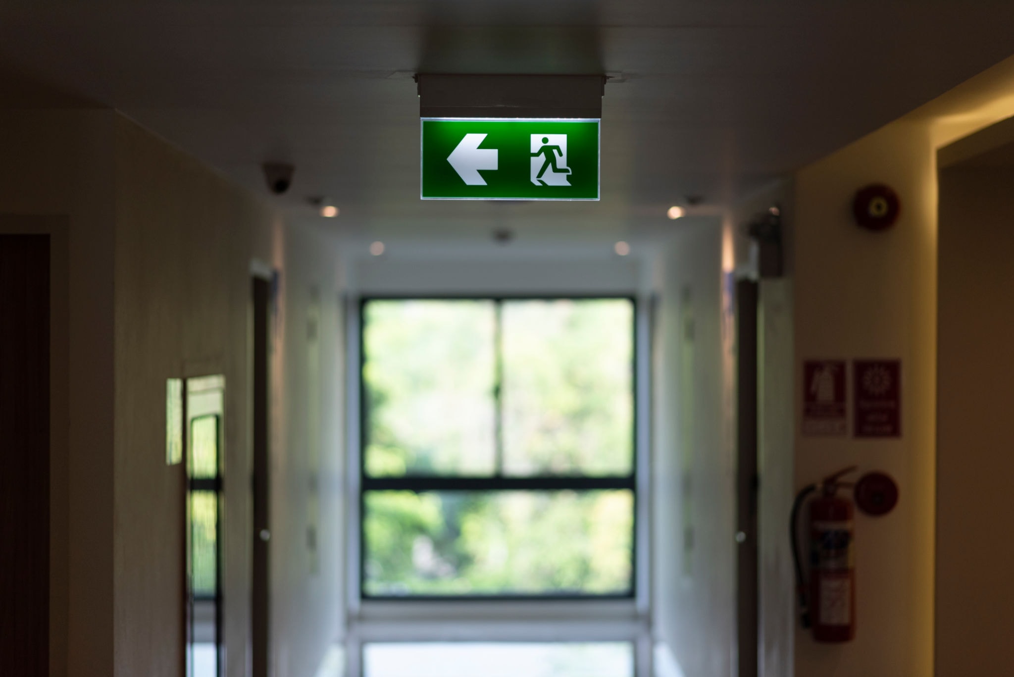 Emergency exit sign illuminated in a commercial corridor